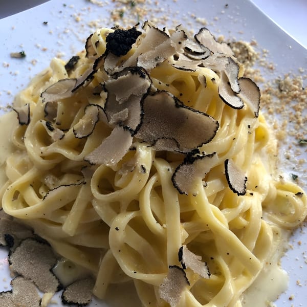 Creamy fettuccine pasta topped with generous shavings of black truffle and grated cheese.