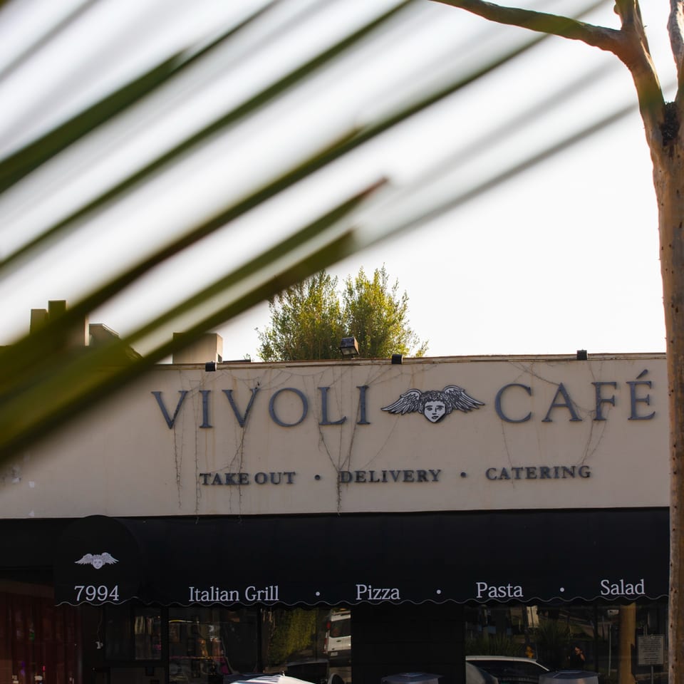 Vivoli Cafe sign with an awning listing "Italian Grill, Pizza, Pasta, Salad" and services.